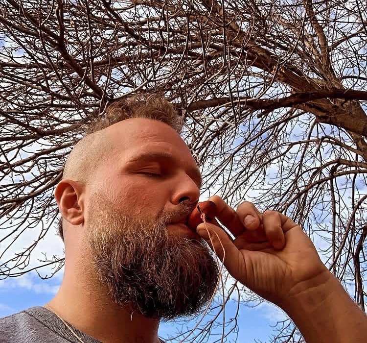 A man breathing through a breathing tree under a bare tree