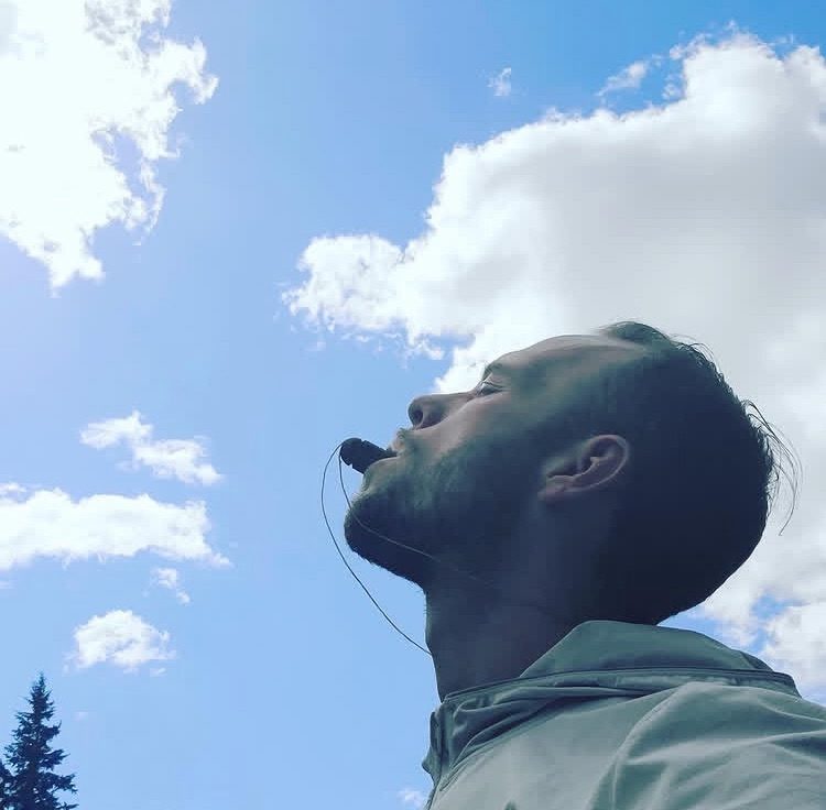 A man breathing through a breathing tree with his face to the sky